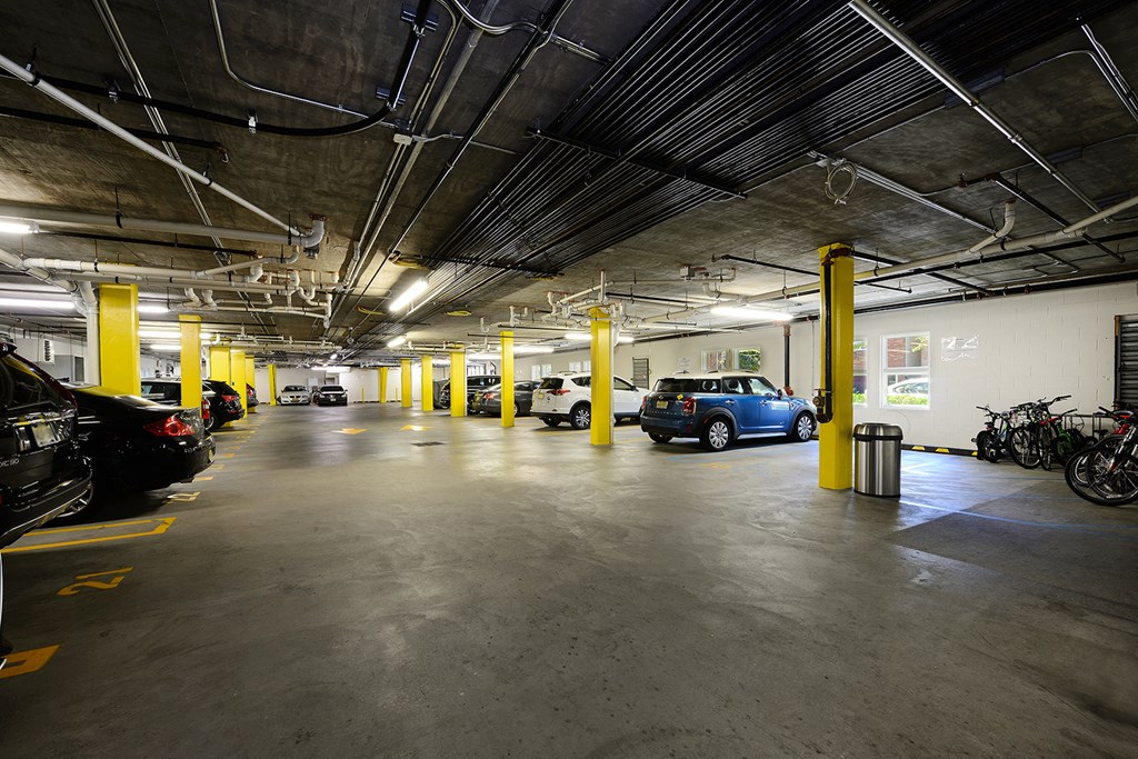 a parking garage with cars and motorcycles and yellow pillars