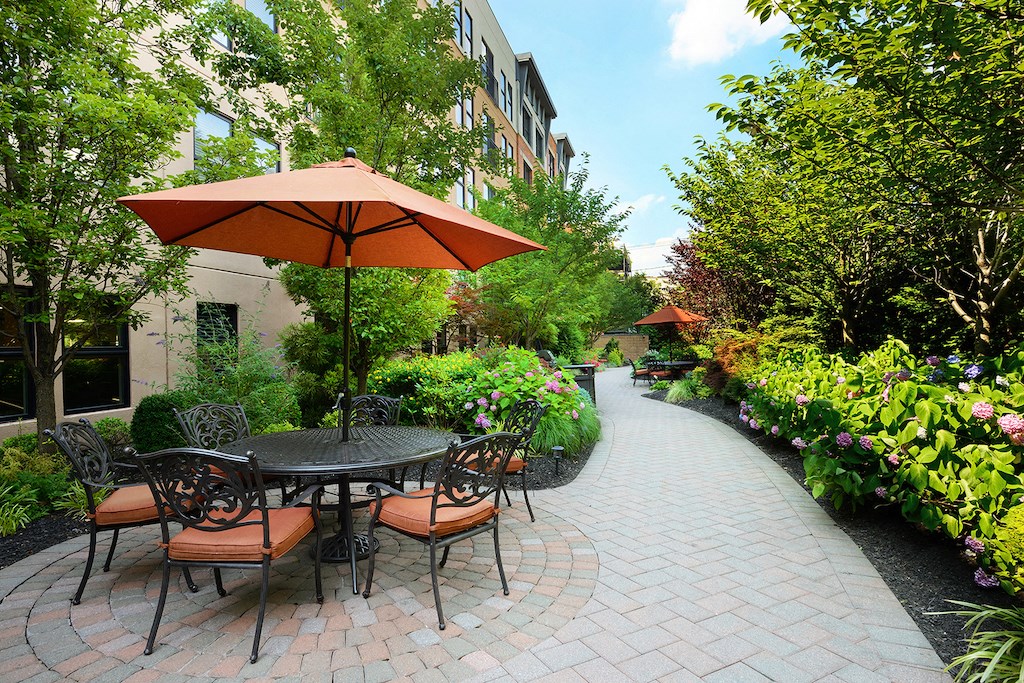 a patio with a table and chairs and umbrellas