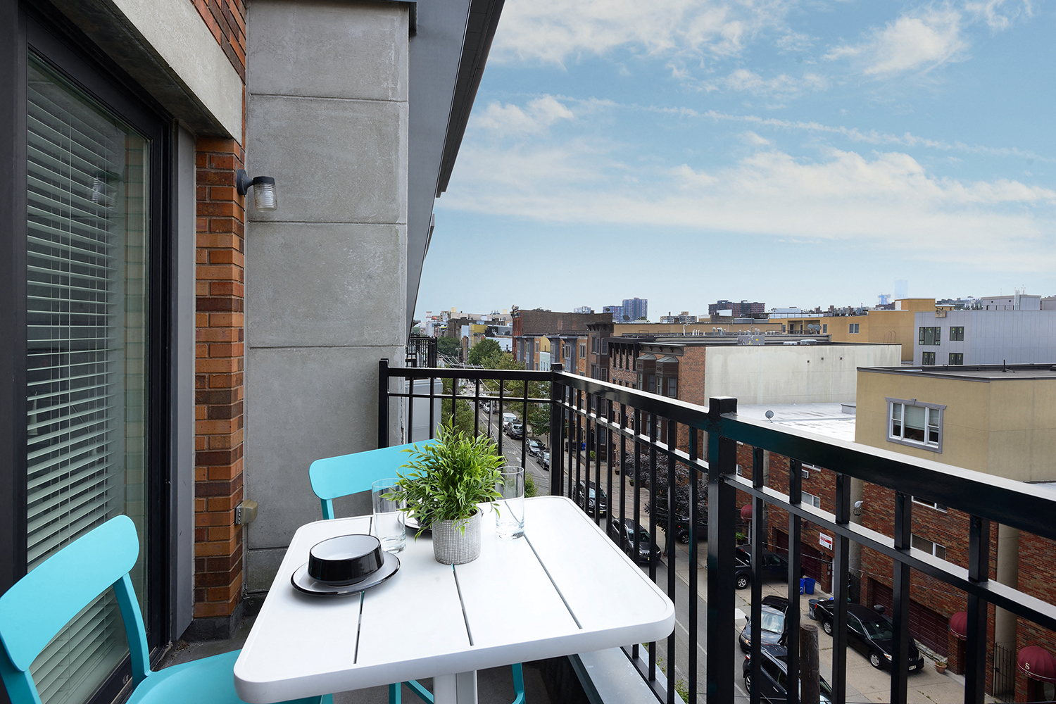 a balcony with a table and chairs and a view of the city