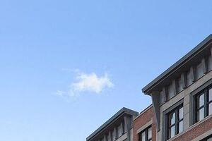 a tall brick building with cars parked in front of it