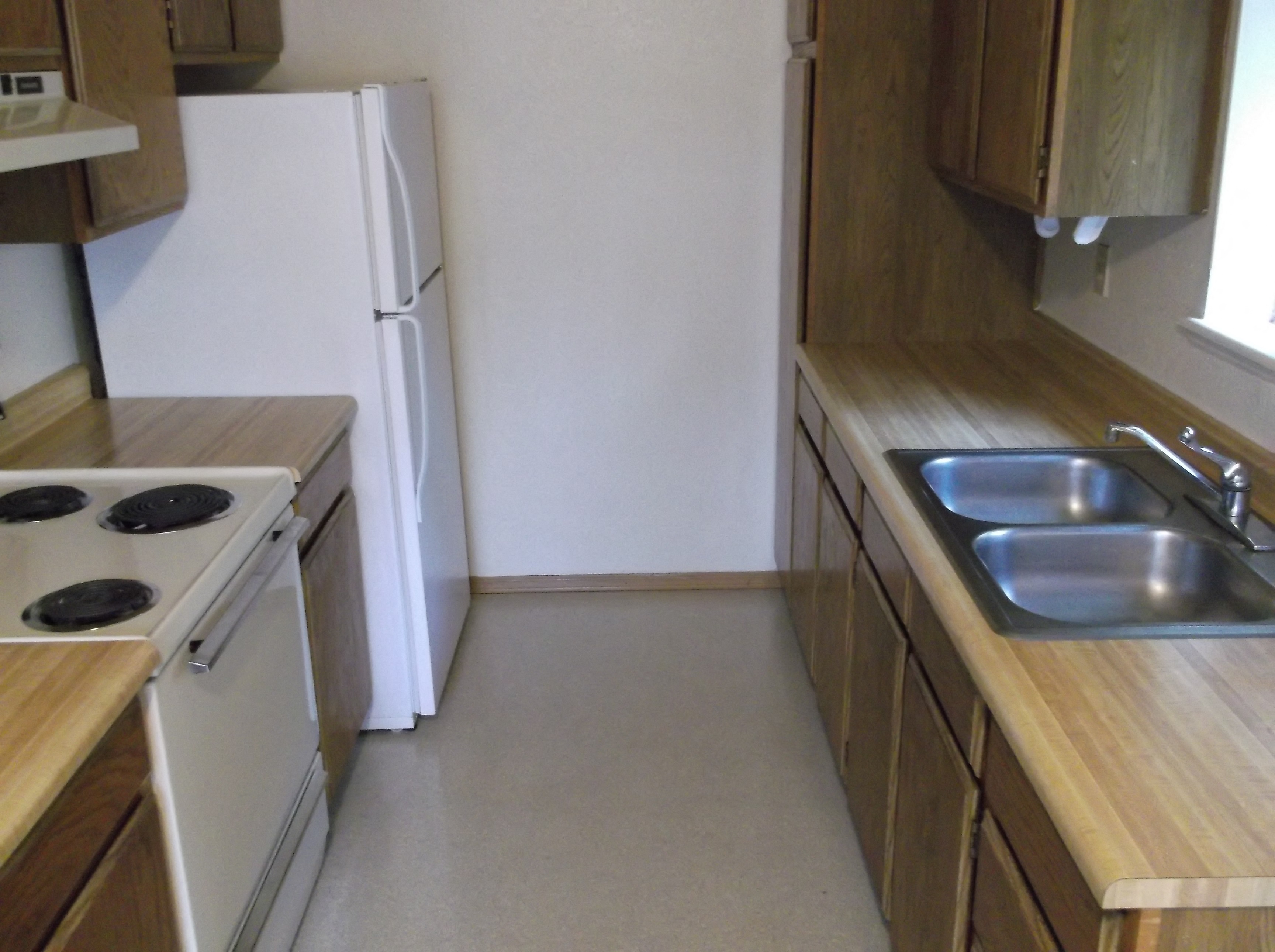 a kitchen with a sink and a stove and a refrigerator
