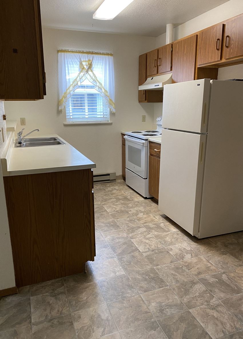 Image of refrigerator, stove, sink, cabinets, and window - Photo Gallery 1