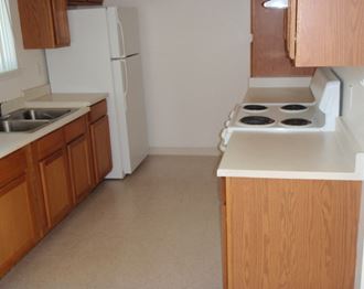 Image of a sink, cabinets, a fridge, and a stove
