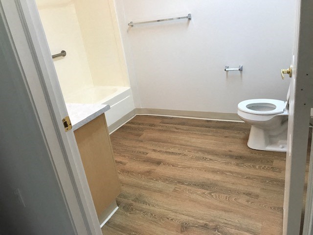 Image of toilet, towel rack, bathtub, and sink