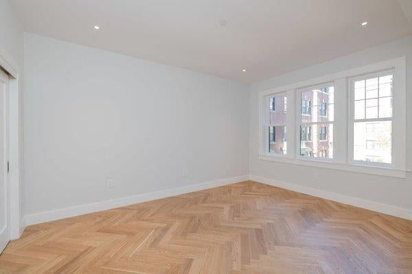 an empty room with wooden floors and a window