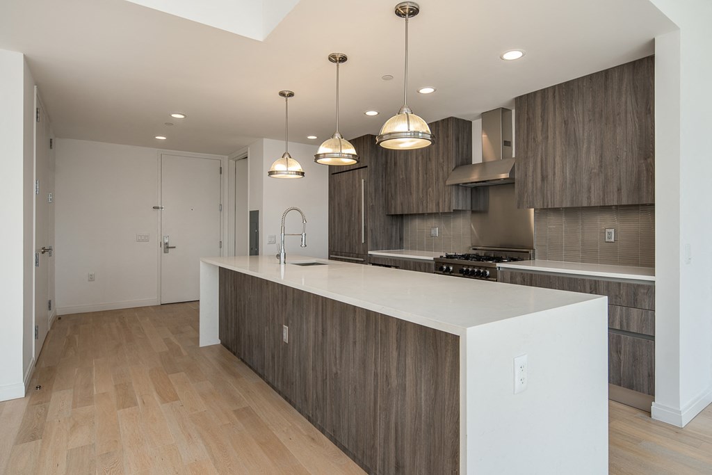 a kitchen with a large white island and wooden cabinets