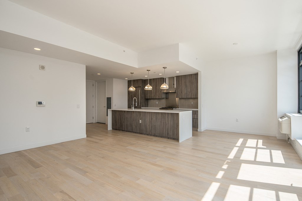 an open kitchen and living room with white walls and wood flooring
