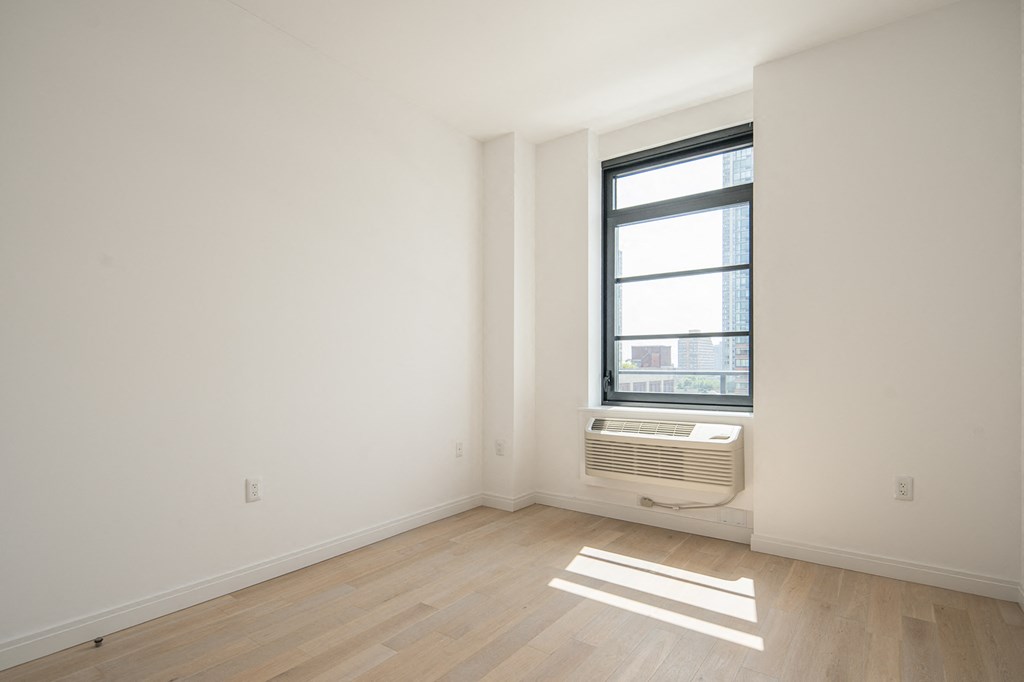 an empty room with a window and a radiator