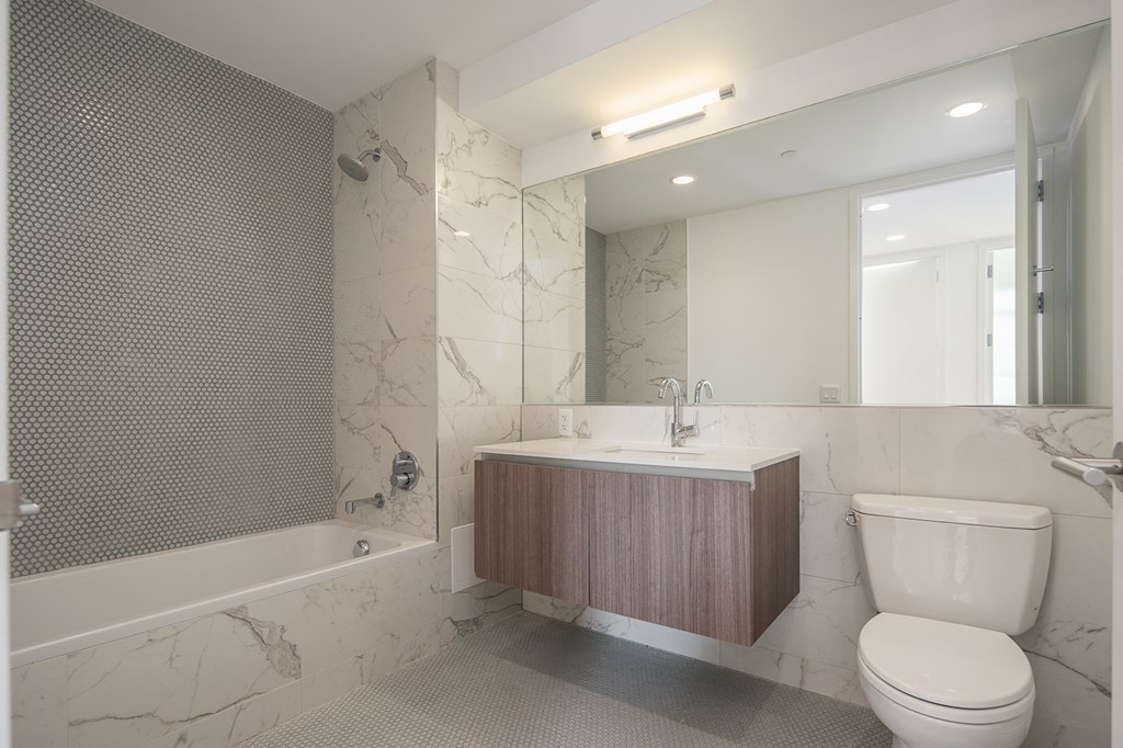 a bathroom with a toilet sink and tub and a mirror