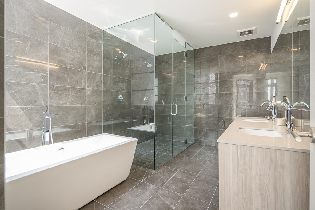 a bathroom with a tub and a shower and a sink