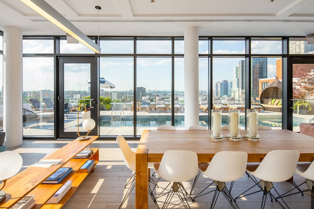 a dining room with a table and chairs and a view of the city