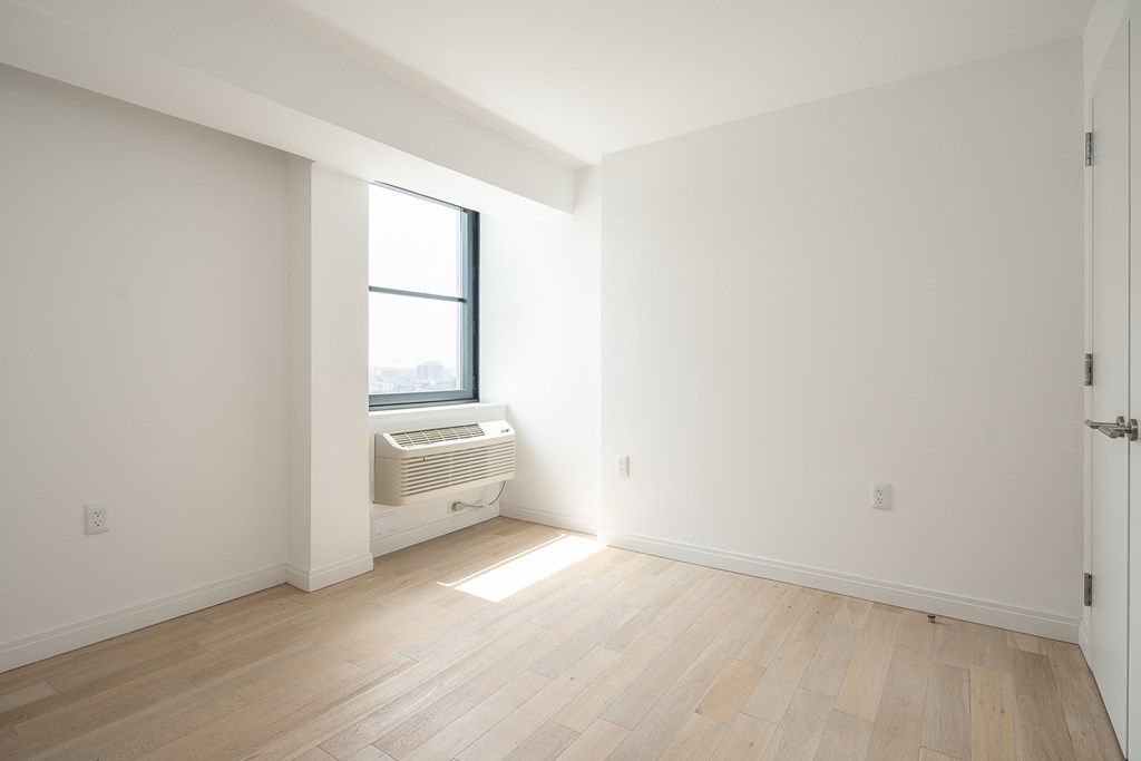 an empty room with a window and a radiator