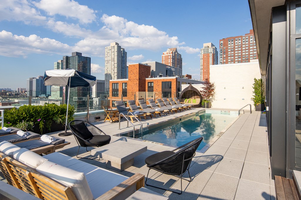 the pool on the rooftop of a building with the city in the background