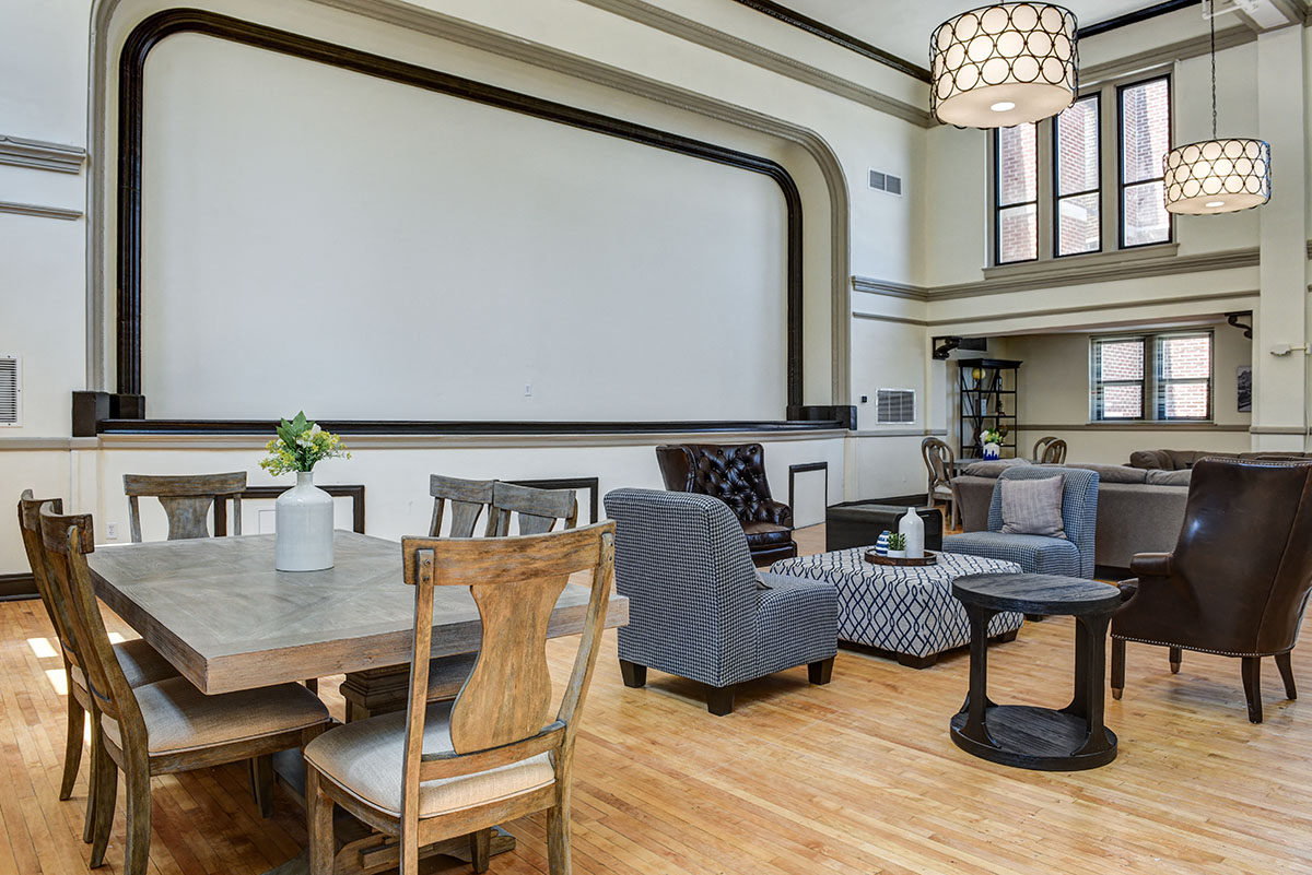 a living room with a table and chairs and a whiteboard