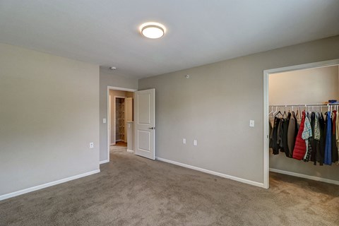 an empty bedroom with a closet and a clothes rack