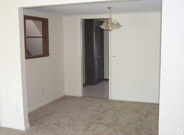 an empty living room with a window and a door