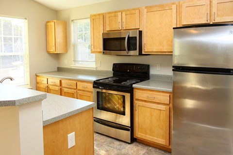 a kitchen with stainless steel appliances and wooden cabinets