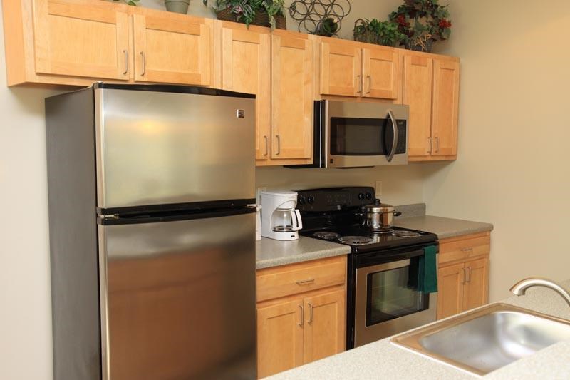a kitchen with stainless steel appliances and wooden cabinets
