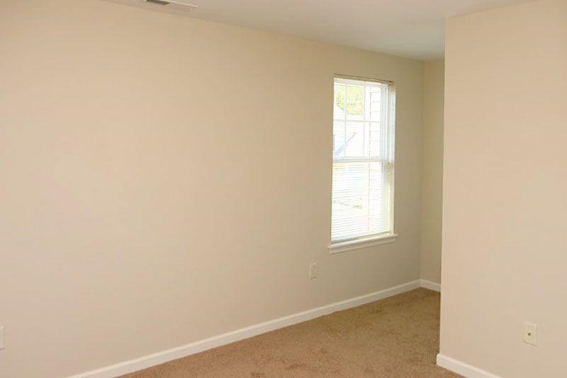 an empty room with a window and a carpet
