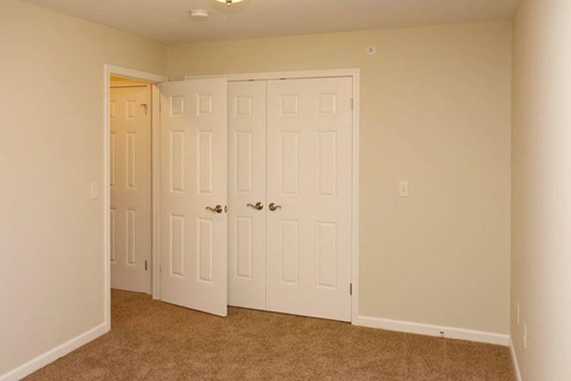 an empty room with two closets and a door