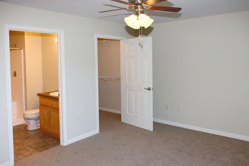 an empty room with a toilet and a ceiling fan