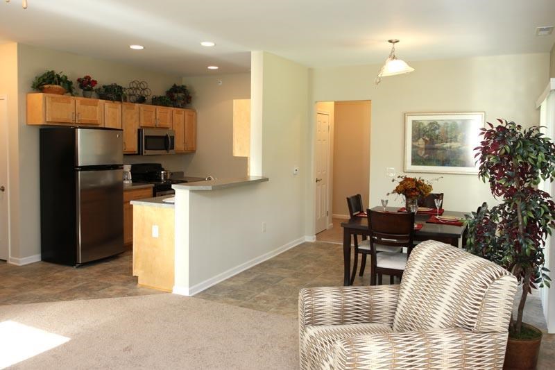 a living room and kitchen with a table and chairs