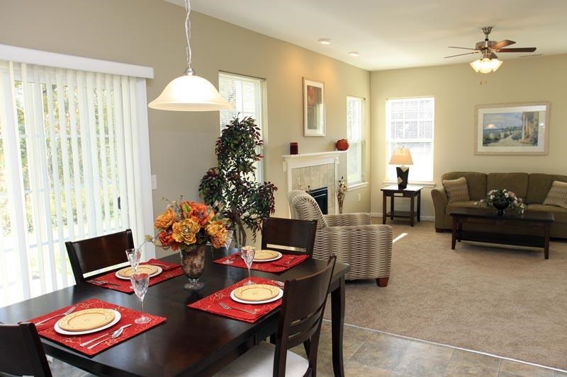 a living room and dining room with a table and chairs