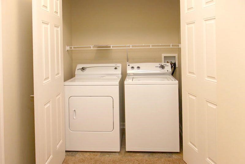 two washer and dryers in a room with white doors