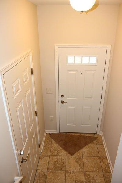 a small hallway with a white door and a tile floor