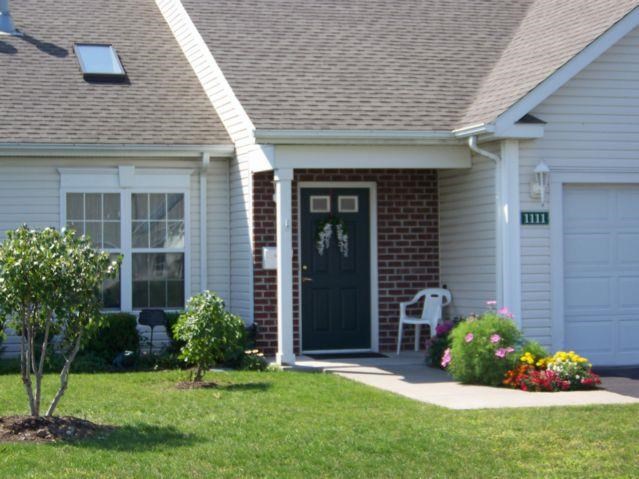 a white house with a black door and a lawn