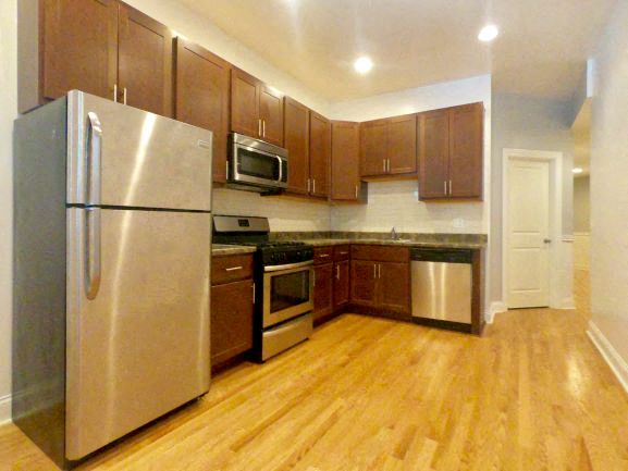 a kitchen with stainless steel appliances and wooden floors