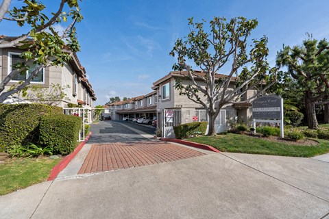 a sidewalk in front of a row of houses with a sign