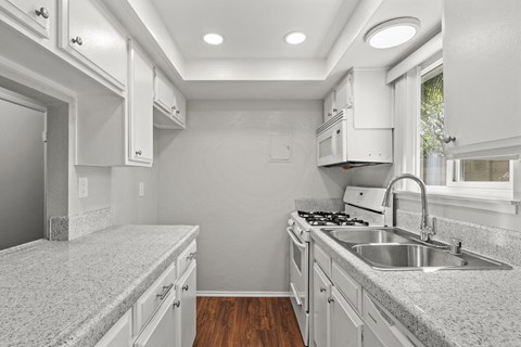a kitchen with granite counter tops and white cabinets