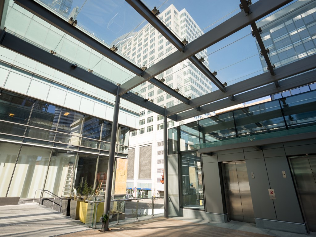 the entrance of a building with tall buildings in the background