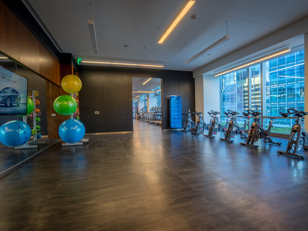 a fitness room with exercise bikes and a large window