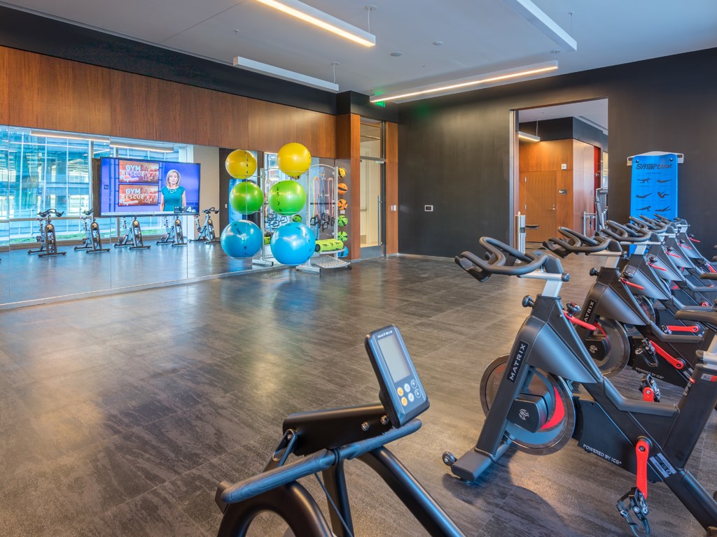 a workout room with exercise bikes and balloons in a gym