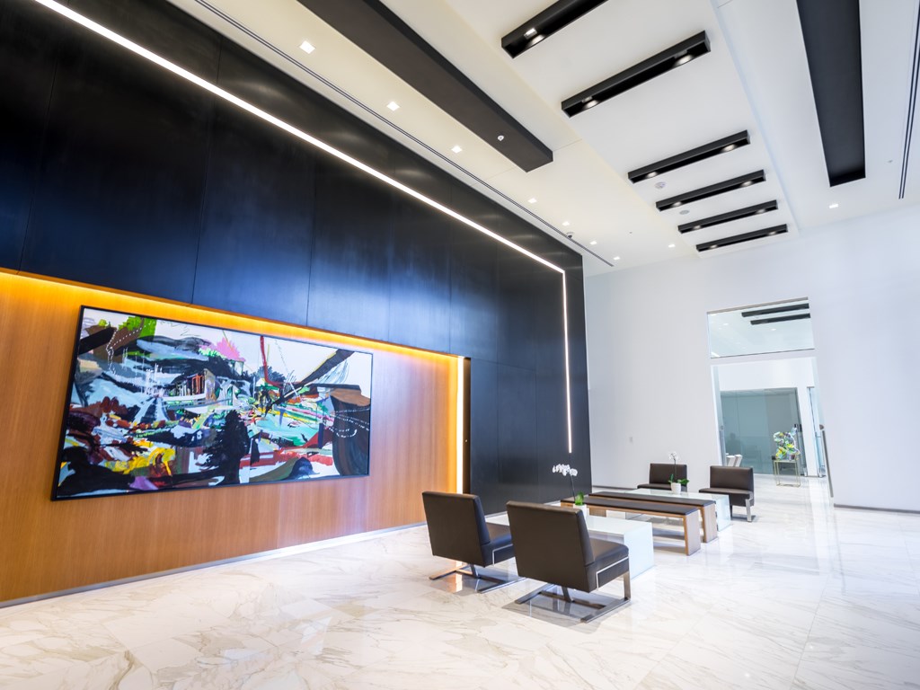 a large lobby with chairs and a painting on the wall
