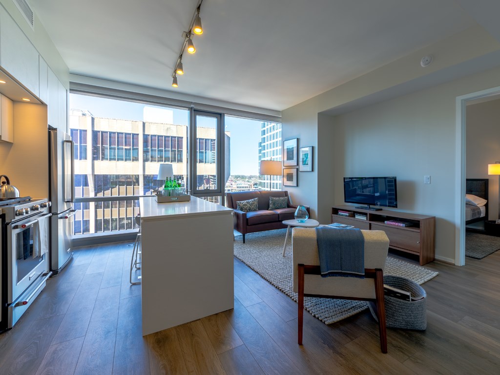 a living room with a kitchen and a large window