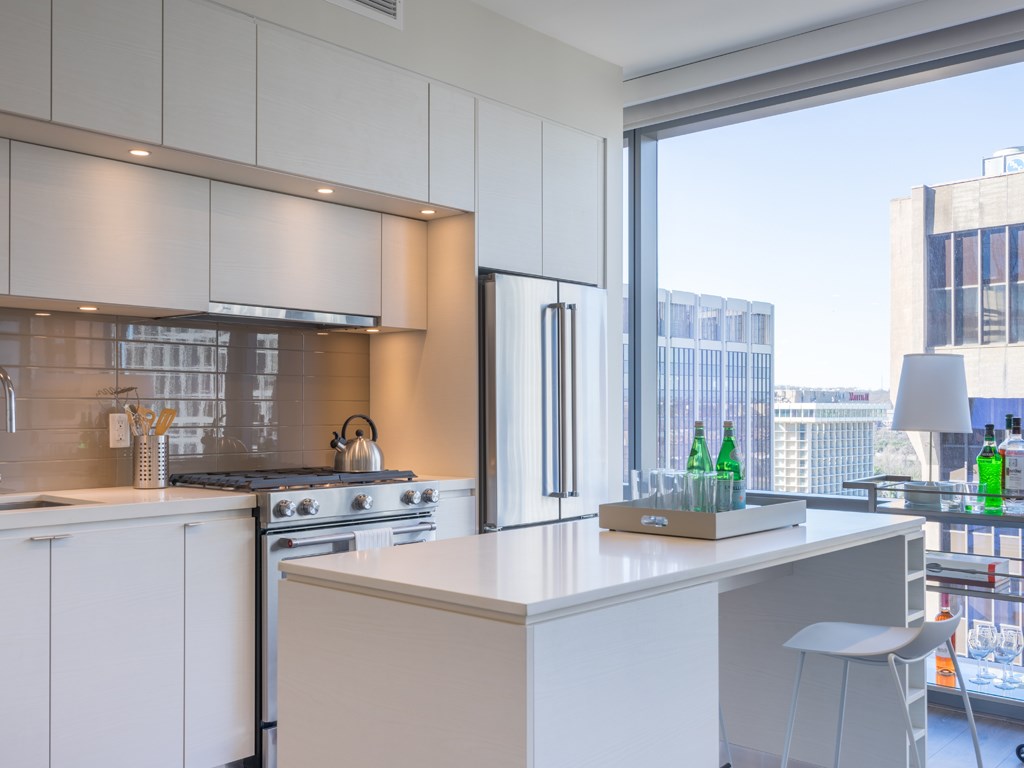 a kitchen with a large window and a counter with a counter top and a refrigerator
