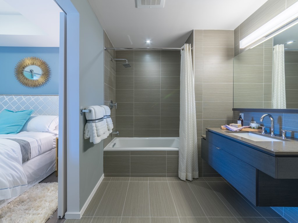 a bathroom with a bed and a sink and a shower