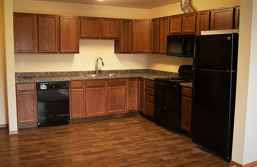 a kitchen with black appliances and wooden cabinets