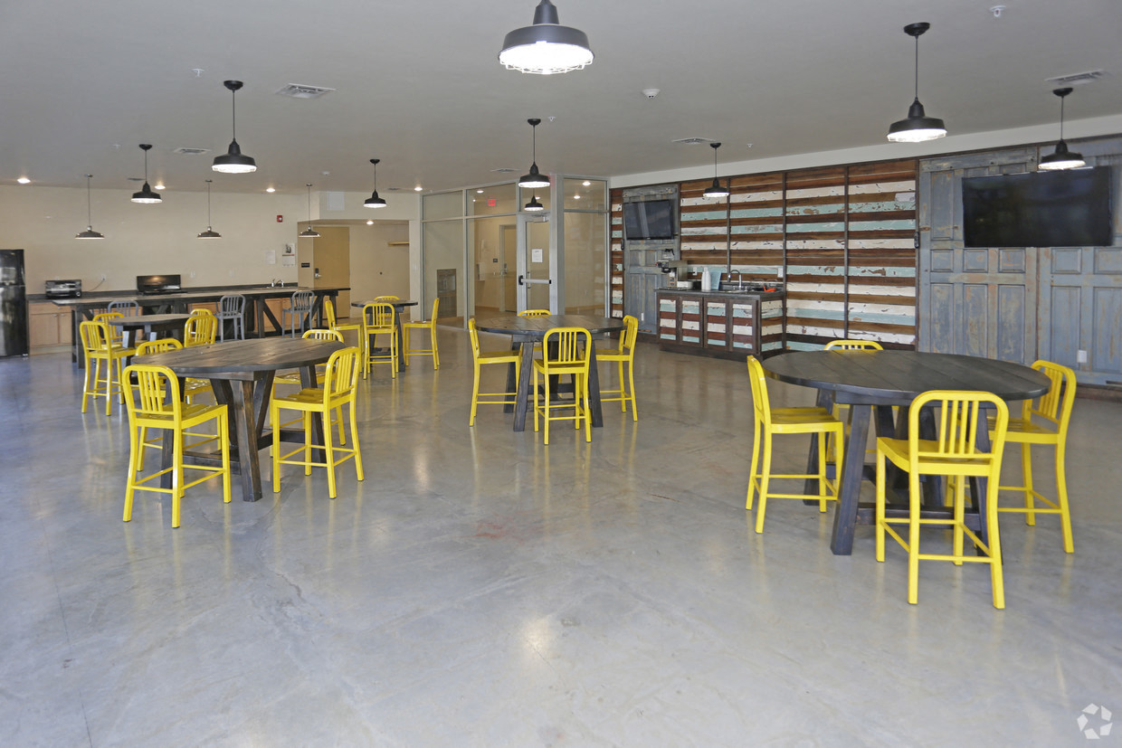 a large room with tables and chairs and a television