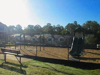 fenced-in community playground with modern equipment