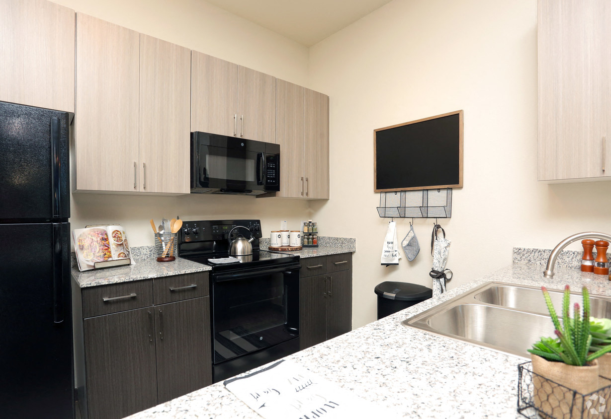 a kitchen with black appliances and granite counter tops