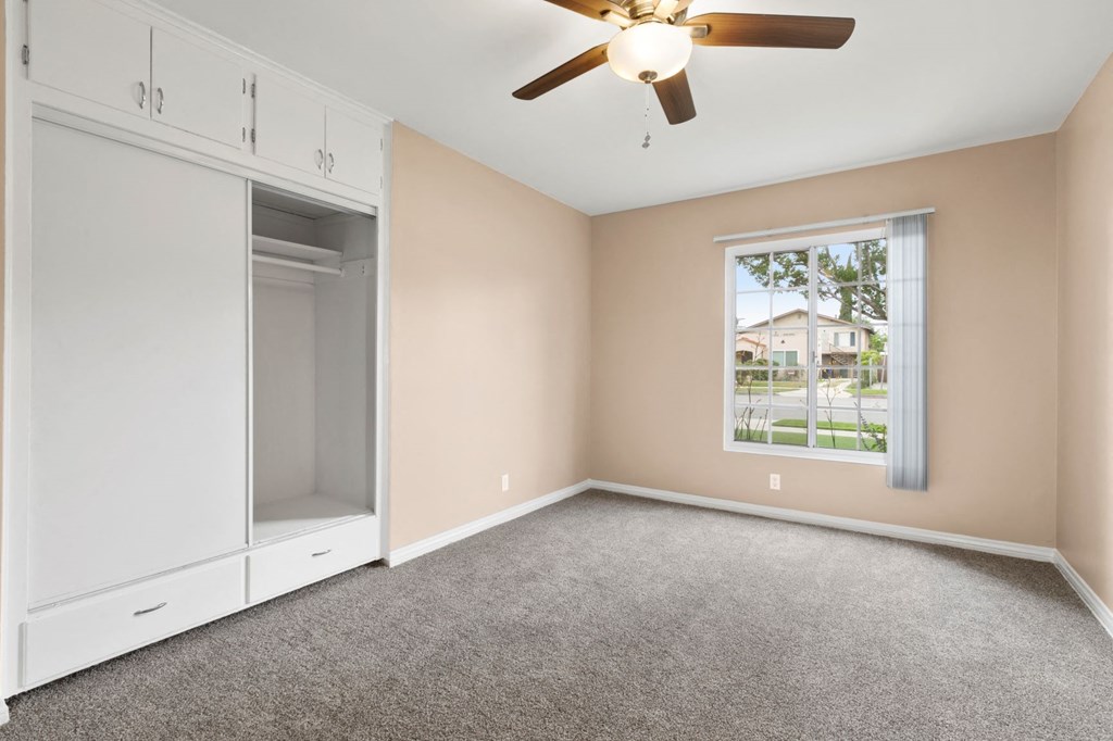 One Bedroom Apartments with Van Nuys, CA - Colonial Manor Spacious Bedroom with Carpet Flooring, Large Closet, and Ceiling Fan