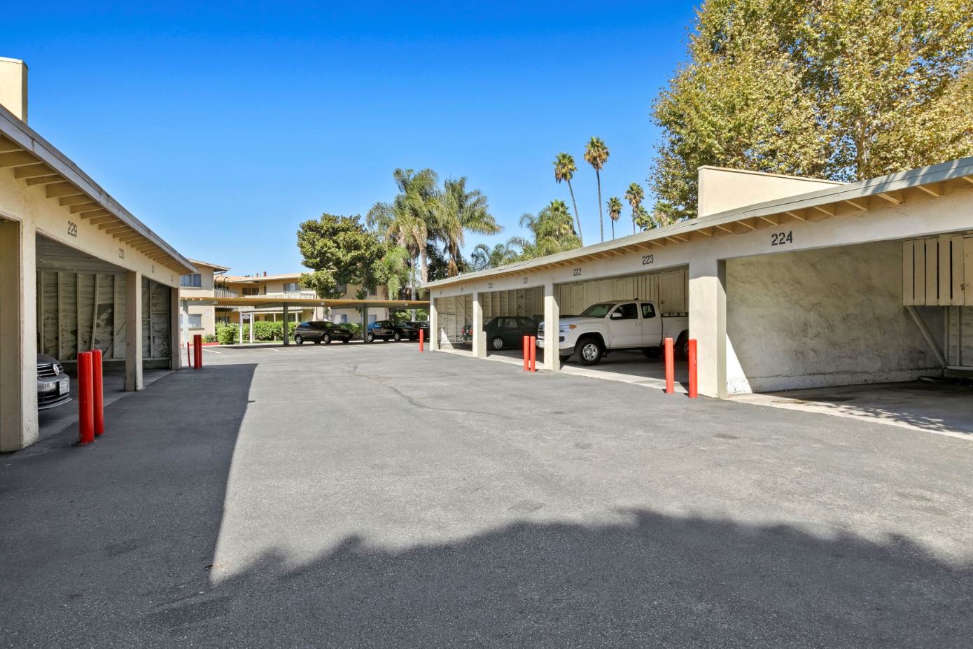 Baldwin Village CA Apartments for Rent - Gloria Homes - Exterior View Of Parking Structure Featuring White Garage Covering Facing Each Other