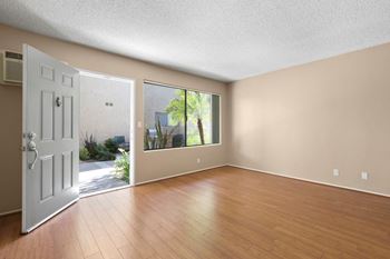 an empty living room with a door leading to a patio