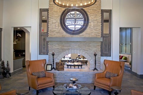 a living room with a stone fireplace and a table and chairs