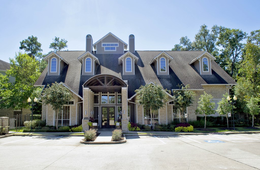 the front of a large house with a driveway and trees