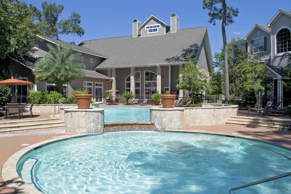 a large swimming pool with a house in the background